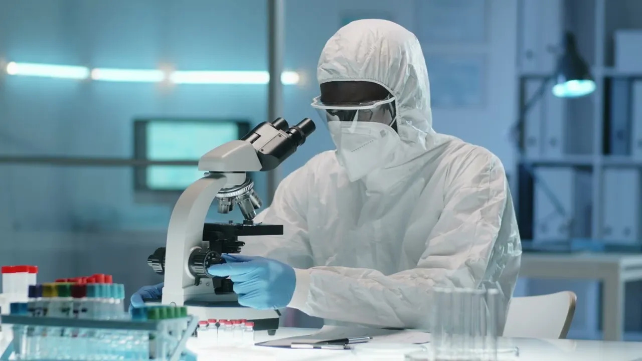 Cleanroom specialist working with a microscope